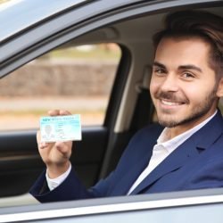 Blije leerling toont haar rijbewijs na praktijkexamen